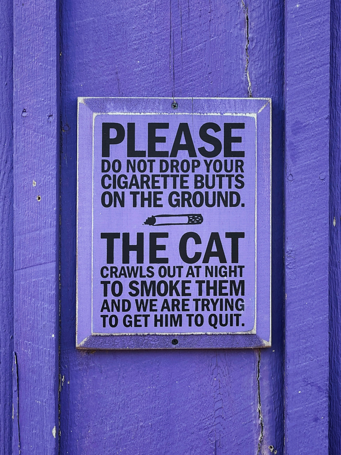 a sign on the side of a purple building