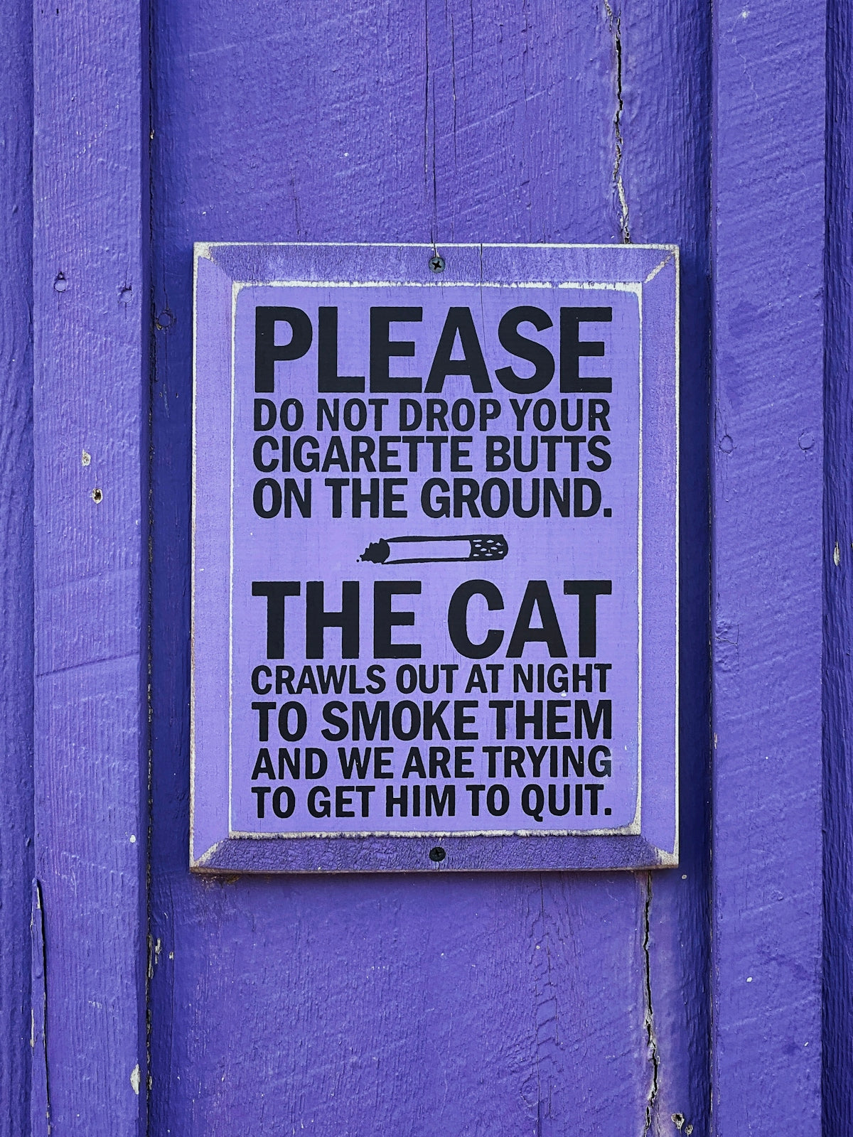 a sign on the side of a purple building
