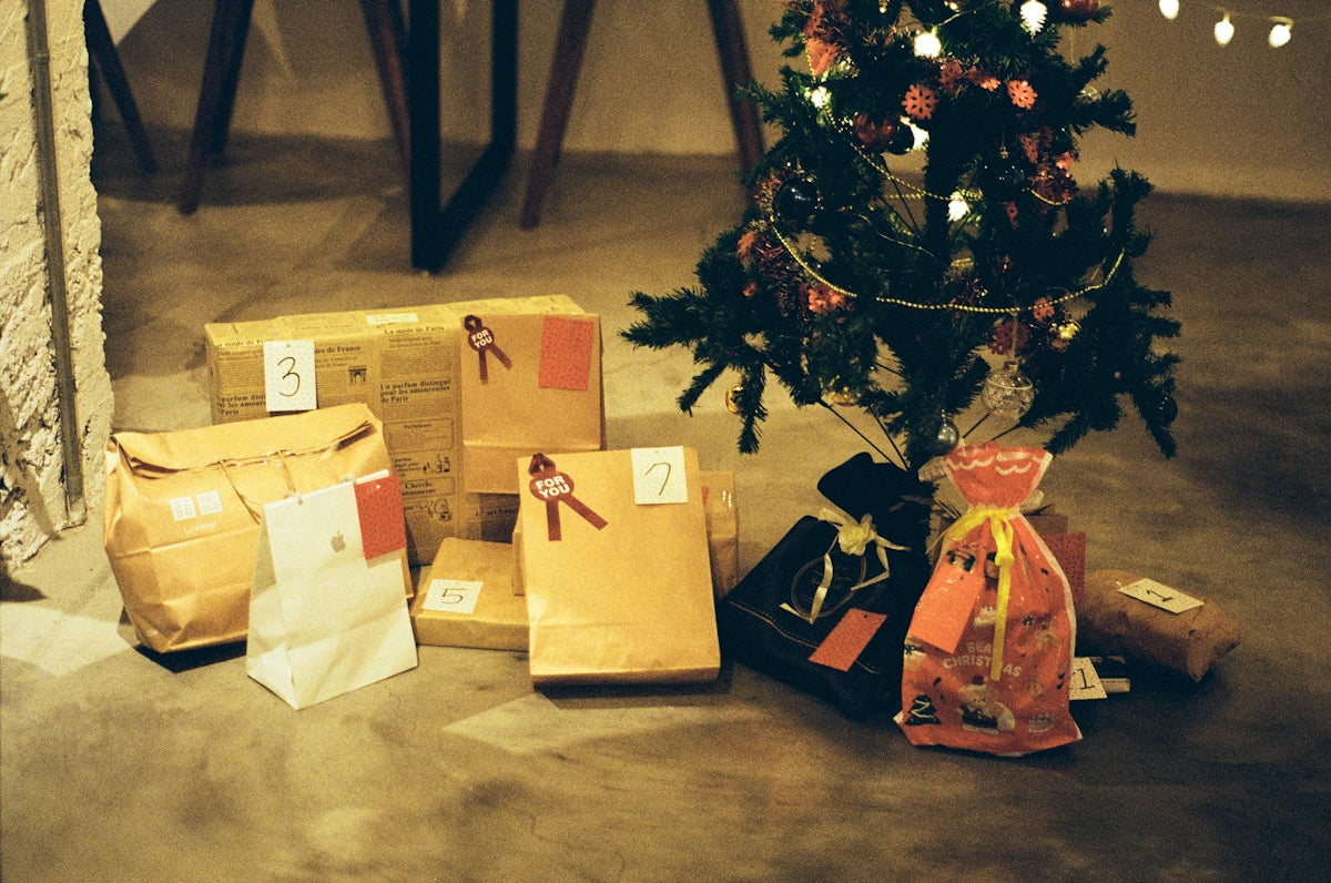 a small christmas tree with presents under it