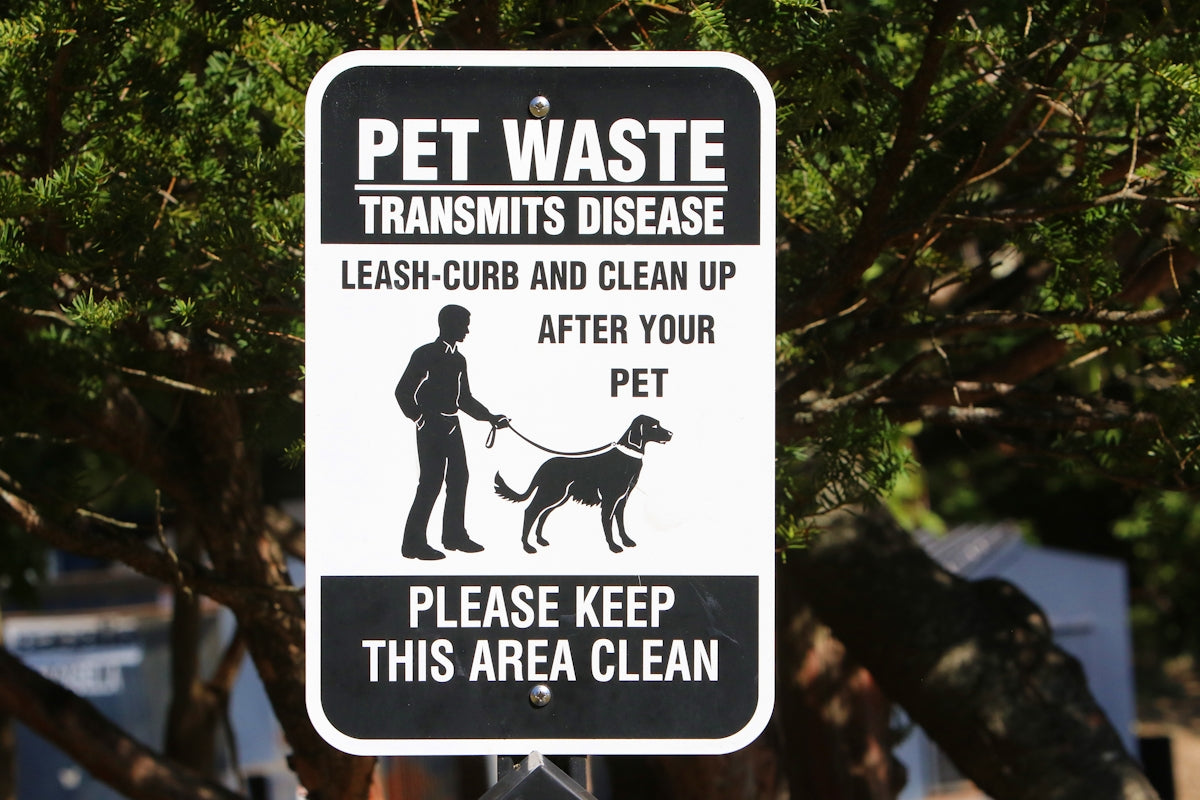 a black and white sign with a man and a dog on it