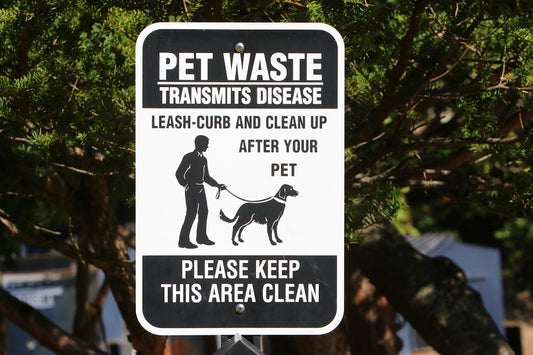 a black and white sign with a man and a dog on it
