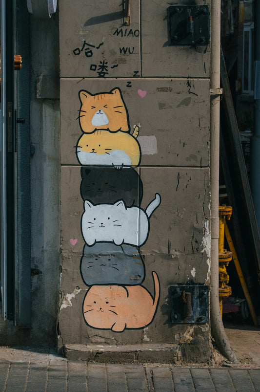 a wall with a bunch of cats painted on it