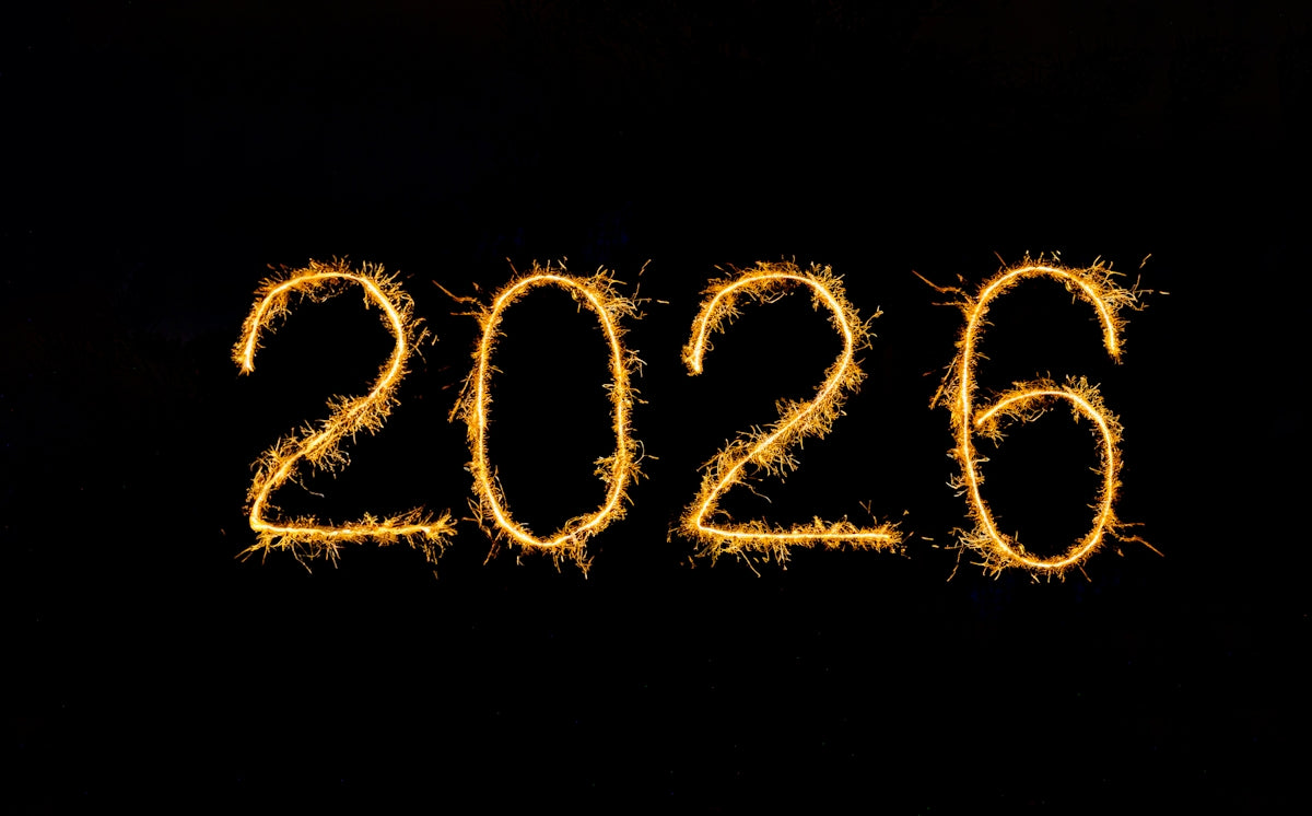 The numbers 2026 written in sparklers on black background